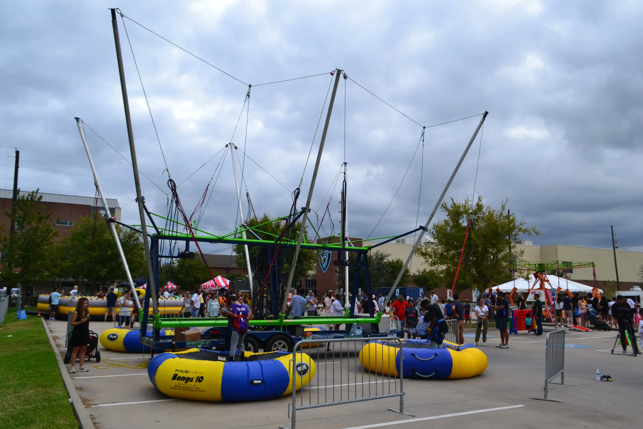 Bungee trampoline ride with crowd at outdoor festival