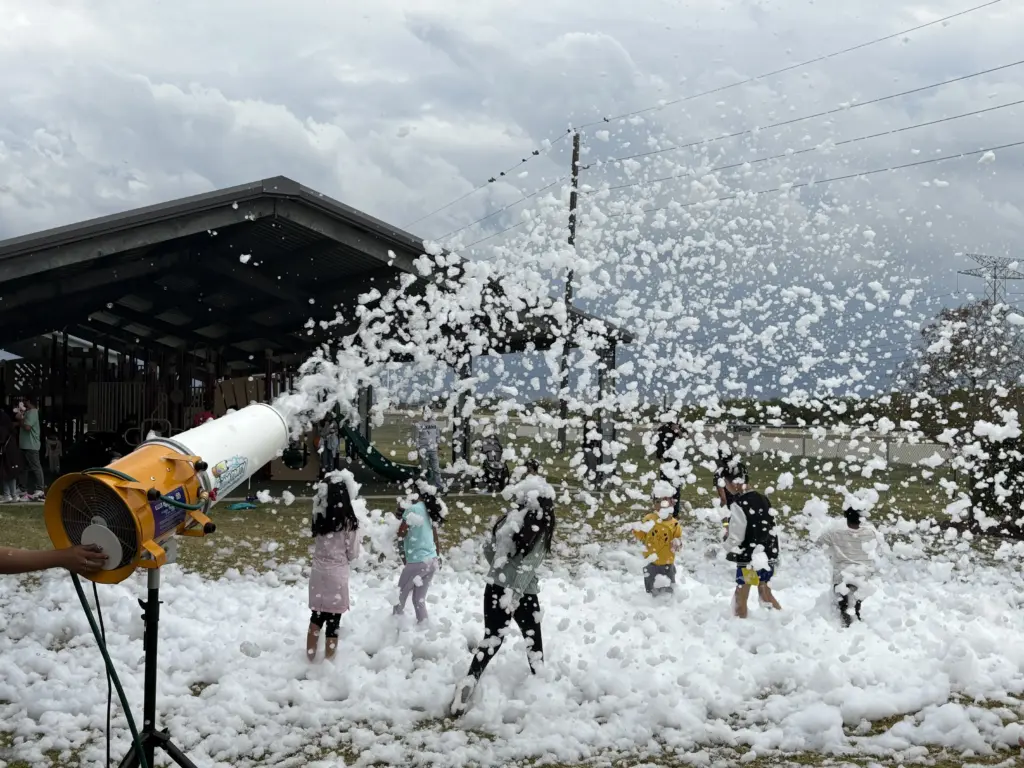 Kids playing in foam machine blast at outdoor party