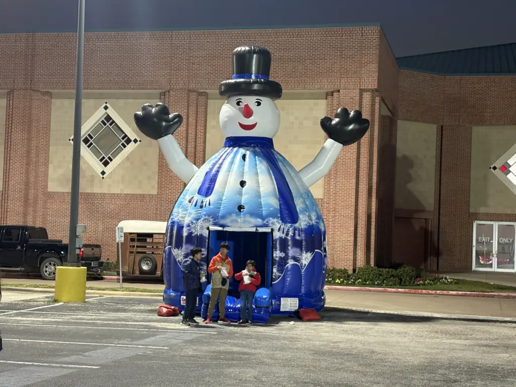 Giant inflatable snowman bounce house at night event
